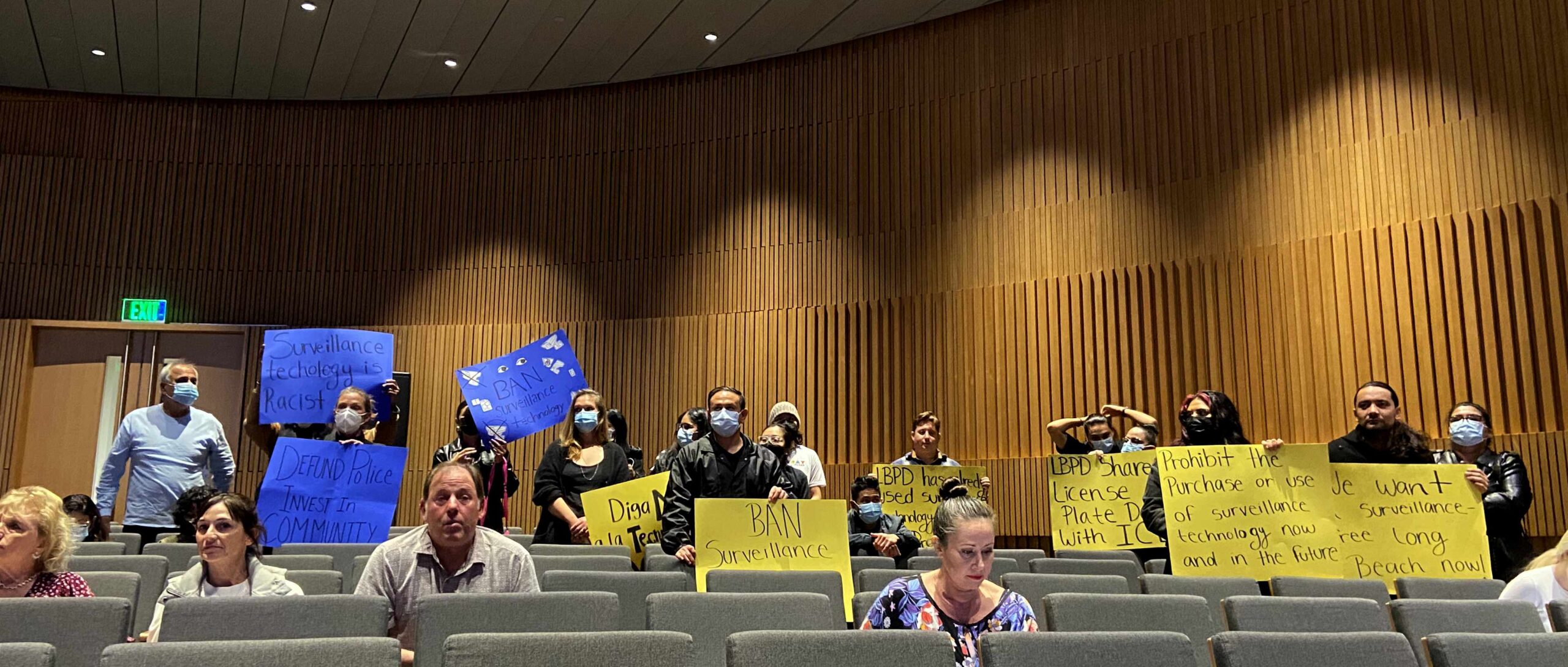 Long Beach residents and activists hold up signs protesting further purchases of Automated License Plate Readers by the Long Beach Police Department at the City Council meeting on Feb. 7, 2023.